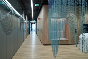 The illusion of a cramped space is created by a glass partition in the corridor