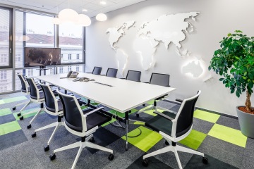 Konferenční prostor se svítící mapou světa na zdi ve firmě CBRE