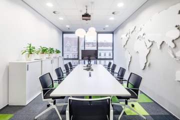 Konferenční prostor se svítící mapou světa na zdi ve firmě CBRE