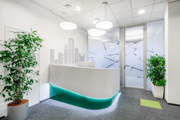 Recepční pult s LED osvětlením a tapetou mrakodrapu ve firmě CBRE