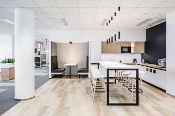 Firemní kuchyňka s barovým stolem a židlemi