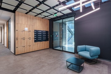 Foyer with armchair, table, lockers and mailboxes