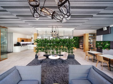 Odpočinková zóna s biofilními prvky a designovým osvětlením od českého výrobce v kancelářích Clifford Chance