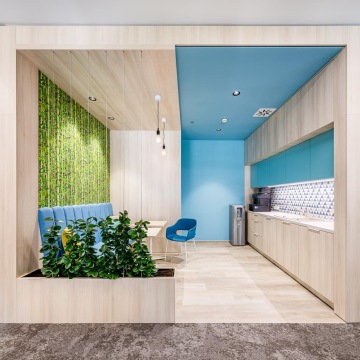 Firemní kuchyňka s prvky zeleně, modré barvy a světlého dřeva