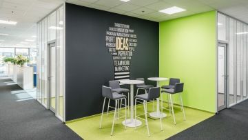 Meeting point s polepem na zdi a barovými židlemi v kancelářích IBM