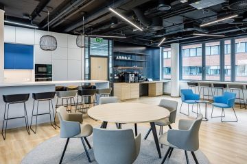 Kuchyňka s barovým ostrůvkem v moderním interiéru kanceláří JTI