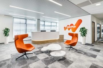 Podsvícený recepční pult s logem LeasePlan na zdi