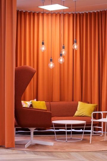 Relaxační zóna v červené barvě s komfortní sedačkou a designovým křeslem