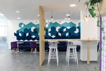 barový a jídlení stůl se zavěšenými žárovkami a akustickou stěnou