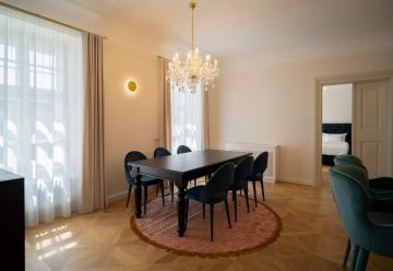 světlý byt se skleněným lustrem a černým stolem