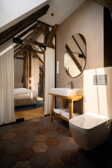 prosvětlená podkrovní koupelna se zrcadlem a průzorem do ložnice