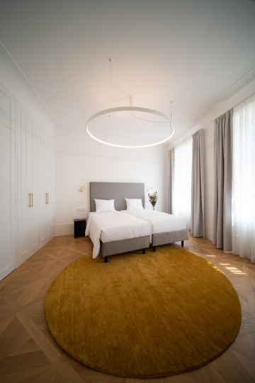 prostorná světlá ložnice s čalouněnou ložnicí