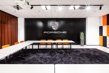 Zasedací místnost s velkým firemním nápisem Porsche