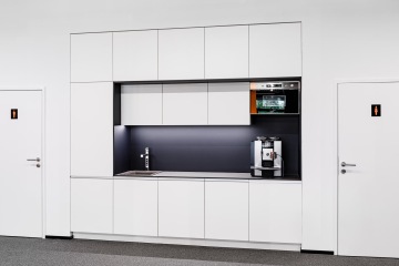 Moderní kuchyňka v bílém provedení s úložným prostorem ve firmě Porsche