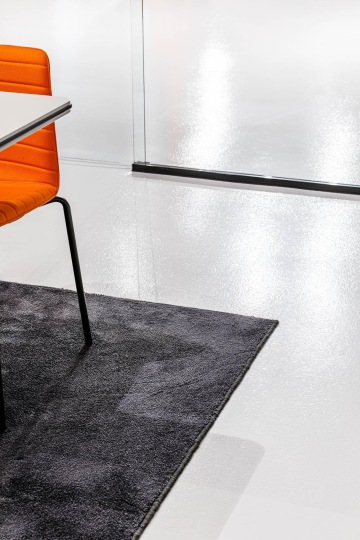 Záběr na židli a atypický kusový koberec