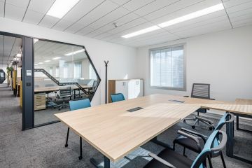 Zasedací místnost s šedým kobercem a dřevěným stolem ve firmě Renault