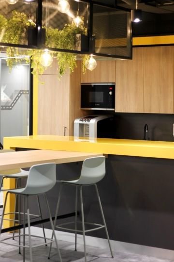 Firemní kuchyňka se žlutým pultem ladící do firemních barev v sídle Renault