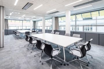 Zasedací místnost s posuvnou bílou stěnou složenou z pěti dílů.