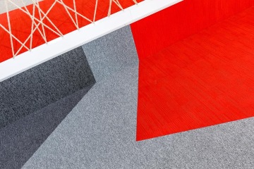 Detail na koberec ve firemních barvách doplněný dekoračním lanem ve firmě Seznam