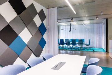 Meeting room in dark blue at company Seznam with acoustic panels on the wall.