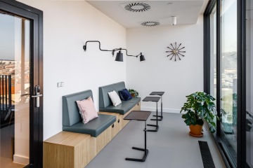 Lavice s mobilními stolky umožňuje pracovat opět s výhledem - coworking, výhled na terasu