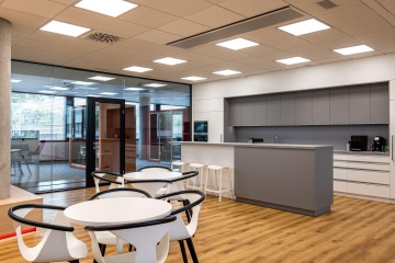 Atraktivní kuchyň s rozměrným ostrůvkem v bílo šedé barvě v kancelářích STATS Perform