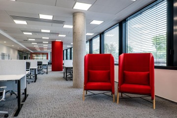 Dvě červené křesílka v open space prostoru pro pohodlné posezení