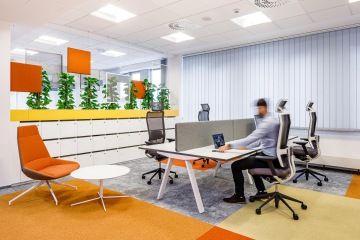 The reconstruction has completely transformed the office – employees moved into an open space with zones where they can choose a workstation depending on their activity. The colours used include yellow and orange