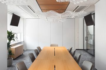 Prostorná zasedací místnost s zavěšenými svítidly ve tvaru mraků