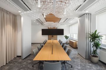 Prostorná zasedací místnost s zavěšenými svítidly ve tvaru mraků