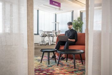 Komfortní kancelářské prostředí s pohodlným nábytkem a různobarevným kobercem v kancelářích Vodafone