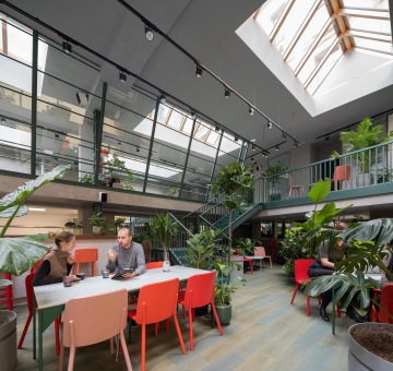 kavárna s designovými barevnými židlemi a rostlinami