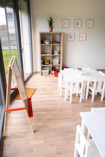 prostor dětské skupiny se stolkem, tabulí a policí