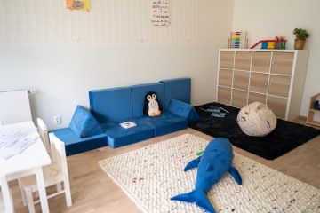prostor dětské skupiny se stolkem a pohovkou