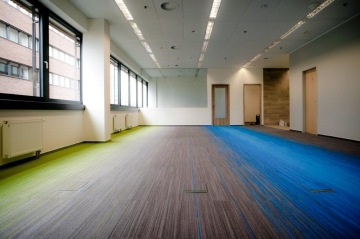 Prostorná kancelář s kobercem Voxflor Color Spring barevně ladí s celým fit-outem pro společnost QBE.