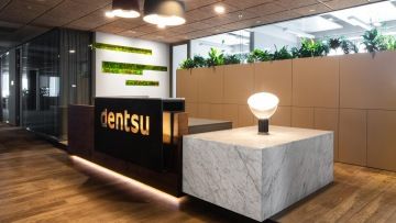 Recepční pult a svítící logo společnosti Dentsu Aegis Network