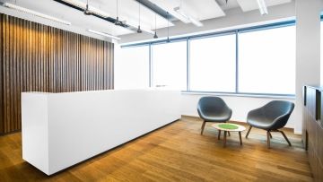 Reception made of artificial stone in white finish in Regus
