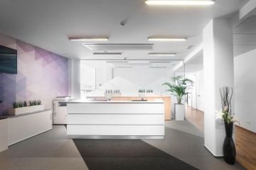 Recepce v bílé barvě a dřevěnými prvky ve firmě Arca Consulting