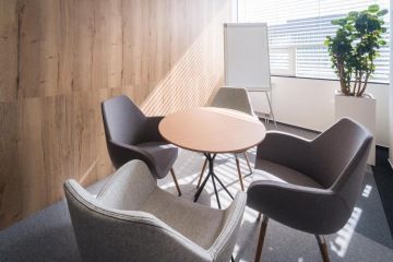 Místnost ve světlých barvách sloužící jako meeting point pro zaměstnance v Arca Consulting