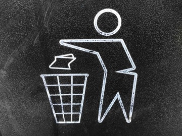 Recyklační černo - bílý symbol panáčka s košem naznačující jak správně třídit odpad.