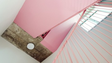 Accent pink stairs in combination with a concrete ceiling