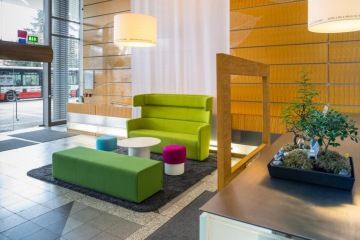 Showroom Ernst and Young působí uvolněně, je zde barevnásedací souprava, velkáá světla a rostliny..