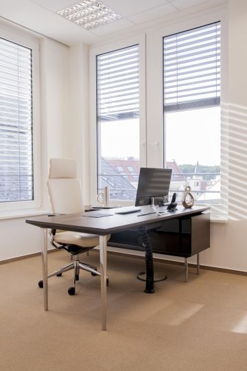 Looking into the manager's office carried out in combination with chrome parts, light beige chairs and dark decorated desk.