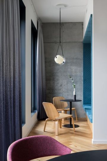 Jídelní místnost s protáhlým stolem a lavicí na sezení v kancelářích Samsung