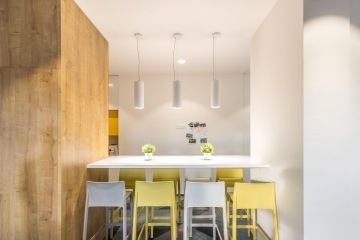 Barový pult s útulným osvětlením a pokojovými rostlinami vybízí k posezení.