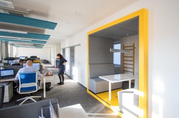 Otevřená zasedací místnost připomínající vlakové kupé umožnuje zaměstnancům rychlé schůzky.