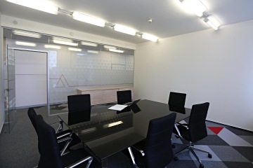 The conference rooms are separated by glass partitions with a logo motif. The motif of the logo and corporate colors are also on carpets.