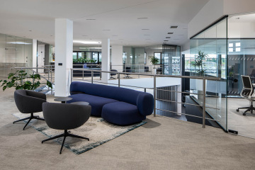 Akcentující modrá pohovka v otevřeném prostoru