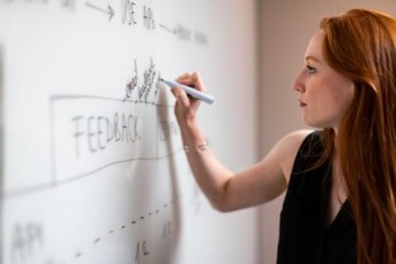 Woman writes with a marker on a blackboard