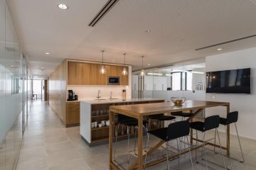 Pracovní kuchyňka s dřevěnými prvky a ostrůvkem v kancelářích firmy GROHE